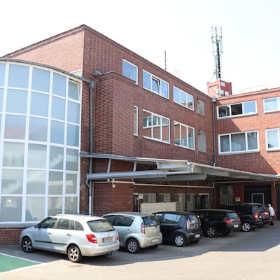 Das Atelierhaus von außen mit davorstehenden Autos.