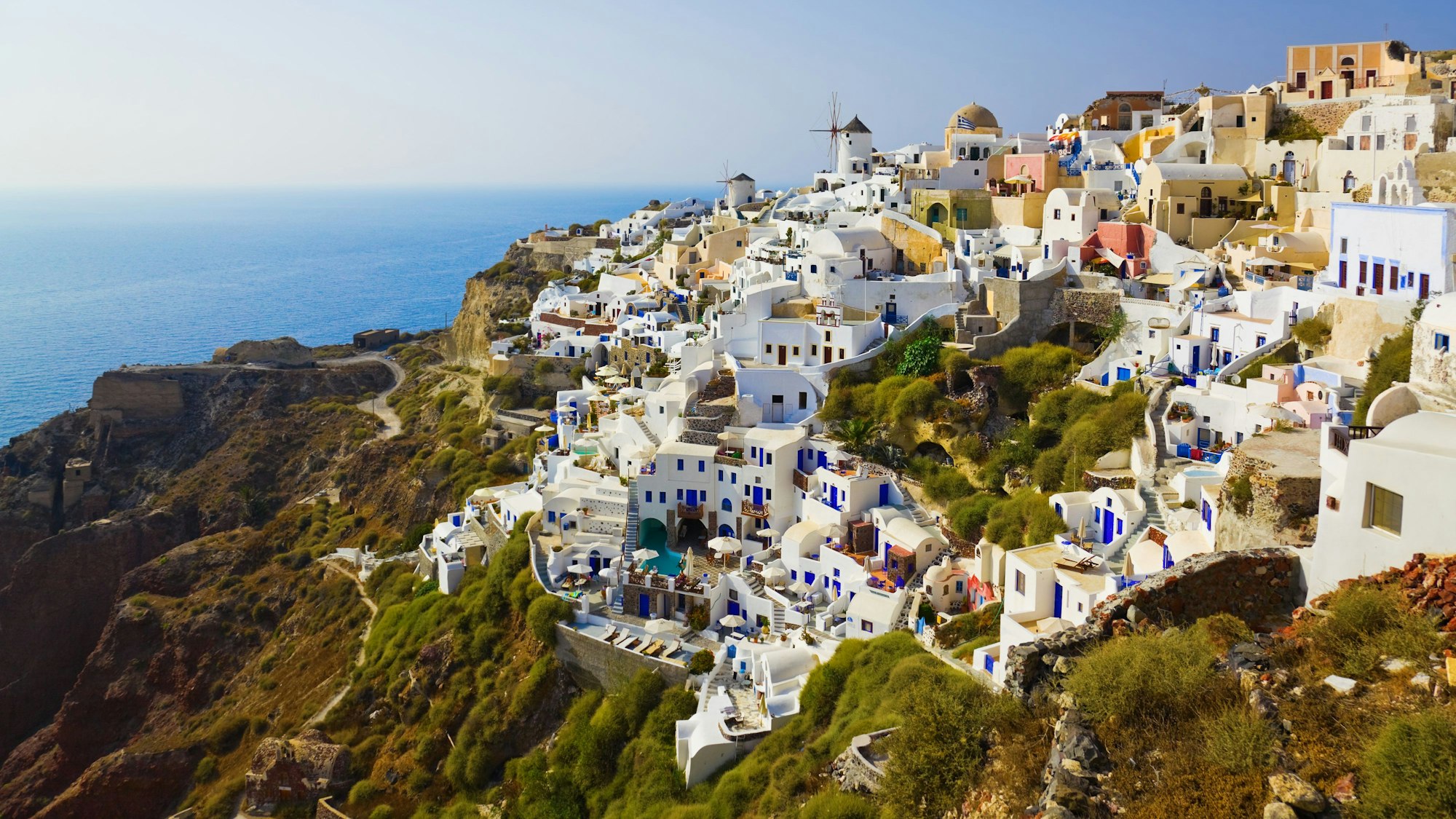 Luftbild: Die griechische Insel Santorin ist berühmt für die blauen Dächer und ein beliebter Urlaubsort für viele Touristinnen und Touristen.