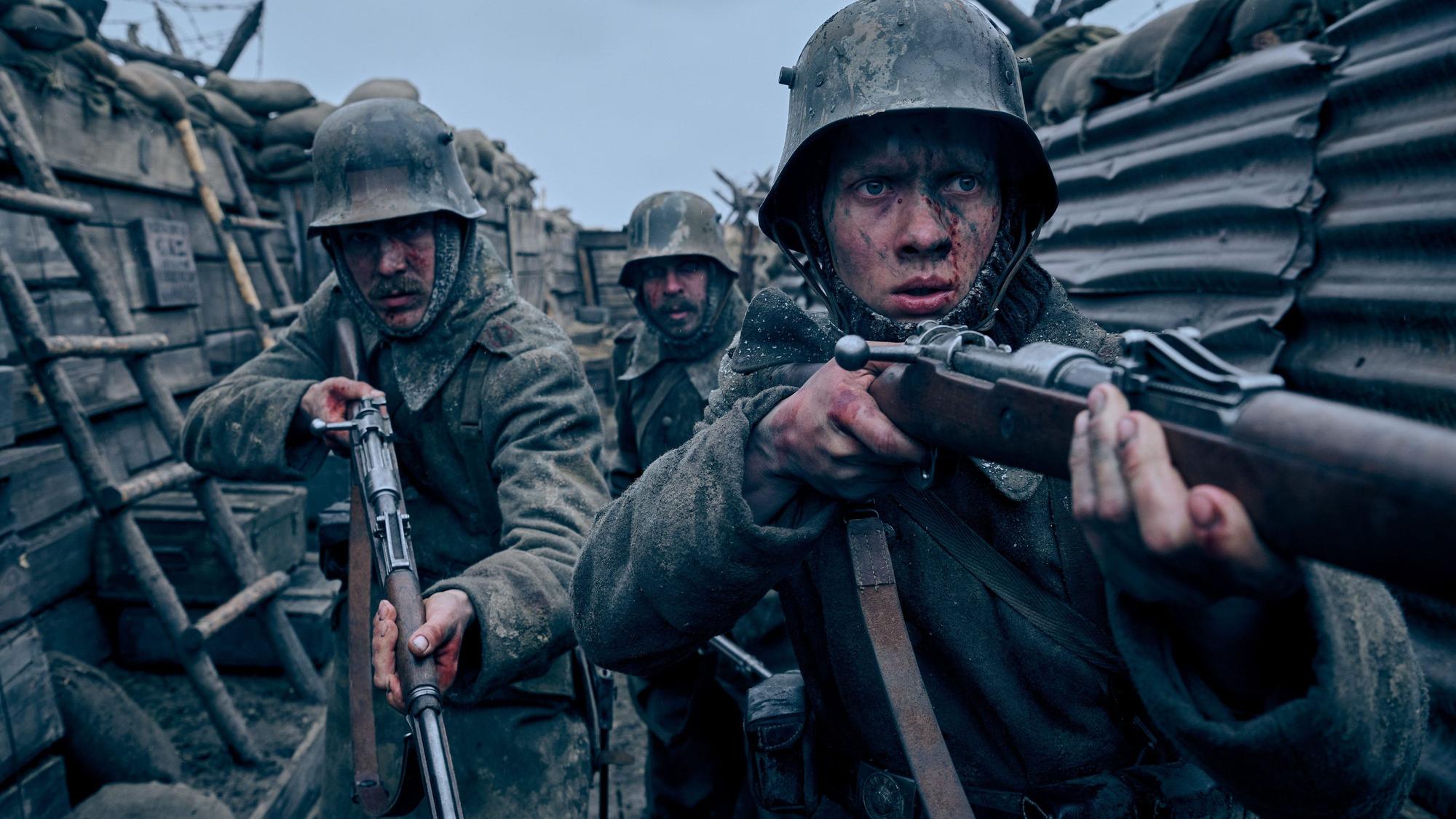 Drei Soldaten mit Gewehren in einem Schützengraben.