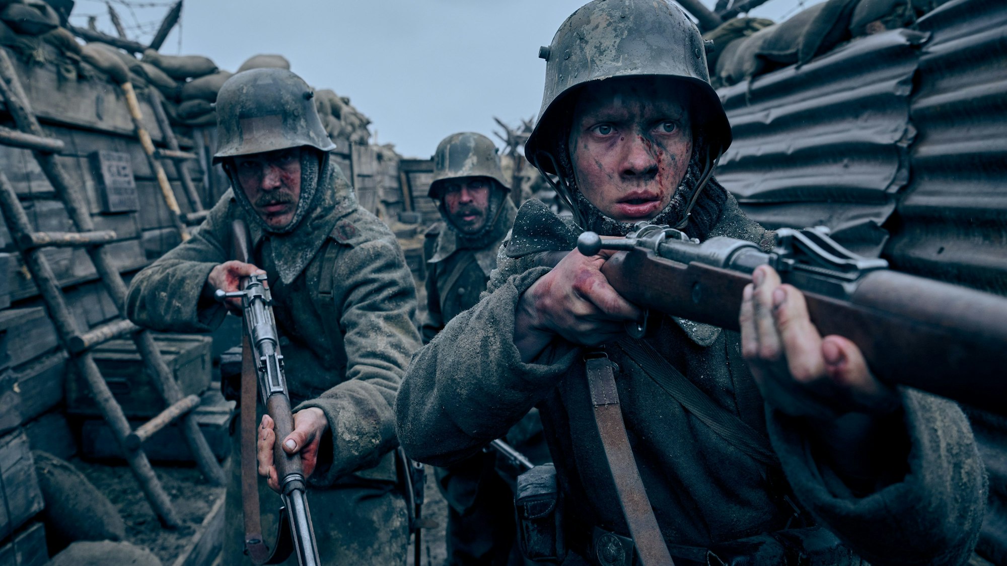 Drei Soldaten mit Gewehren in einem Schützengraben.