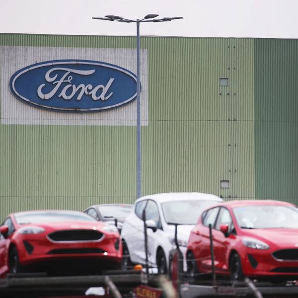 Neu gebaute Autos stehen auf Lastwagen vor dem Ford Werk in Köln.