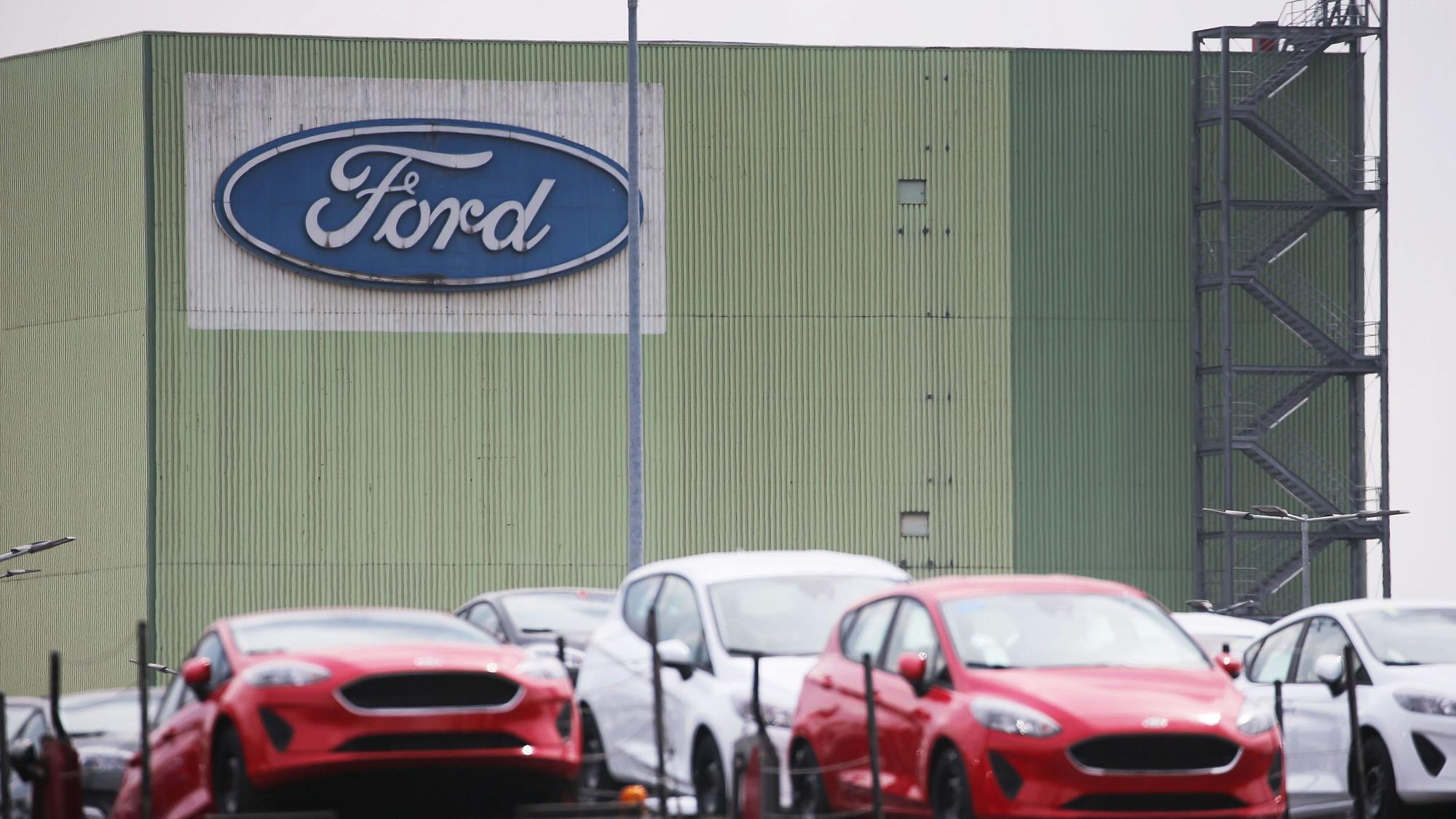 Neu gebaute Autos stehen auf Lastwagen vor dem Ford Werk in Köln.