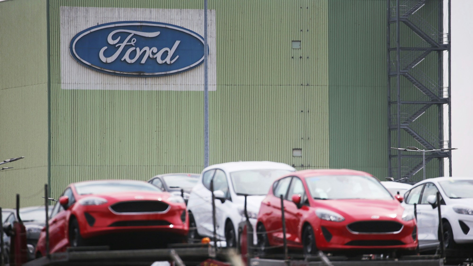 ARCHIV - 03.05.2021, Nordrhein-Westfalen, Köln: Neu gebaute Autos stehen auf Lastwagen vor dem Ford Werk. Der Autobauer Ford will an seinem Kölner Standort nach Angaben des Betriebsrats im großen Stil Jobs abbauen. (zu dpa «IG Metall: Ford will in Köln bis zu 3200 Stellen abbauen») Foto: Oliver Berg/dpa +++ dpa-Bildfunk +++