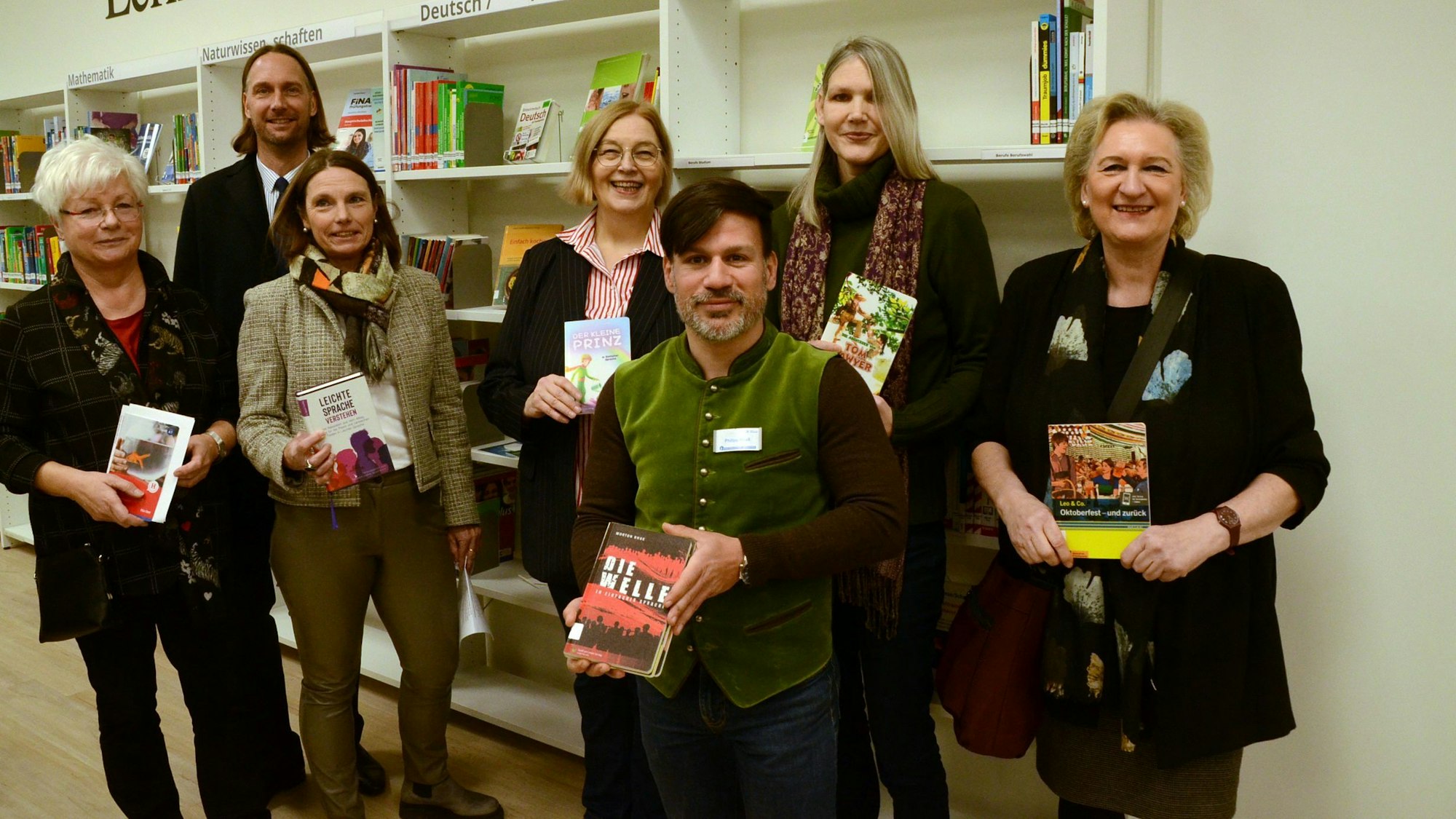 Die Mitarbeiter und Mitarbeiterinnen der Stadtbibliothek Troisdorf halten die Bücher mit Einfacher Sprache in der Hand.