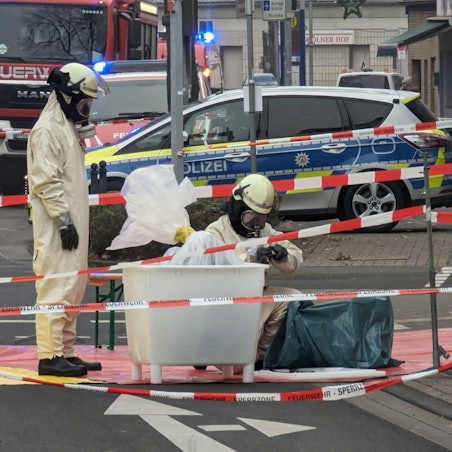Zwei Einsatzkräfte begutachten die Substanz in Schutzanzügen in einem abgesperrten Bereich.