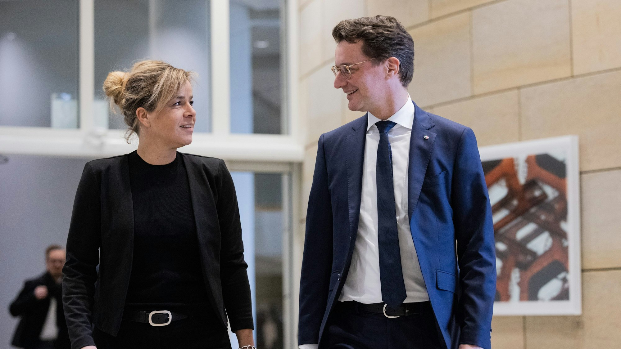 Mona Neubaur (Bündnis 90/Die Grünen, l), Ministerin für Wirtschaft, Industrie, Klimaschutz und Energie sowie stellvertretende Ministerpräsidentin, und Ministerpräsdent Hendrik Wüst (CDU) kommen zur Landespressekonferenz im Landtag, um über aktuelle politische Themen der Landesregierung zu informieren. Sie lächeln sich an im Gespräch.