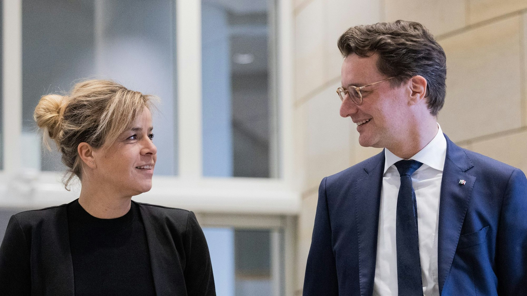 NRW-Ministerpräsident Hendrik Wüst (CDU, r),und seine Stellvertreterin Mona Neubaur (Grüne), Ministerin für Wirtschaft, Industrie, Klimaschutz und Energie sehen einander lächelnd an.