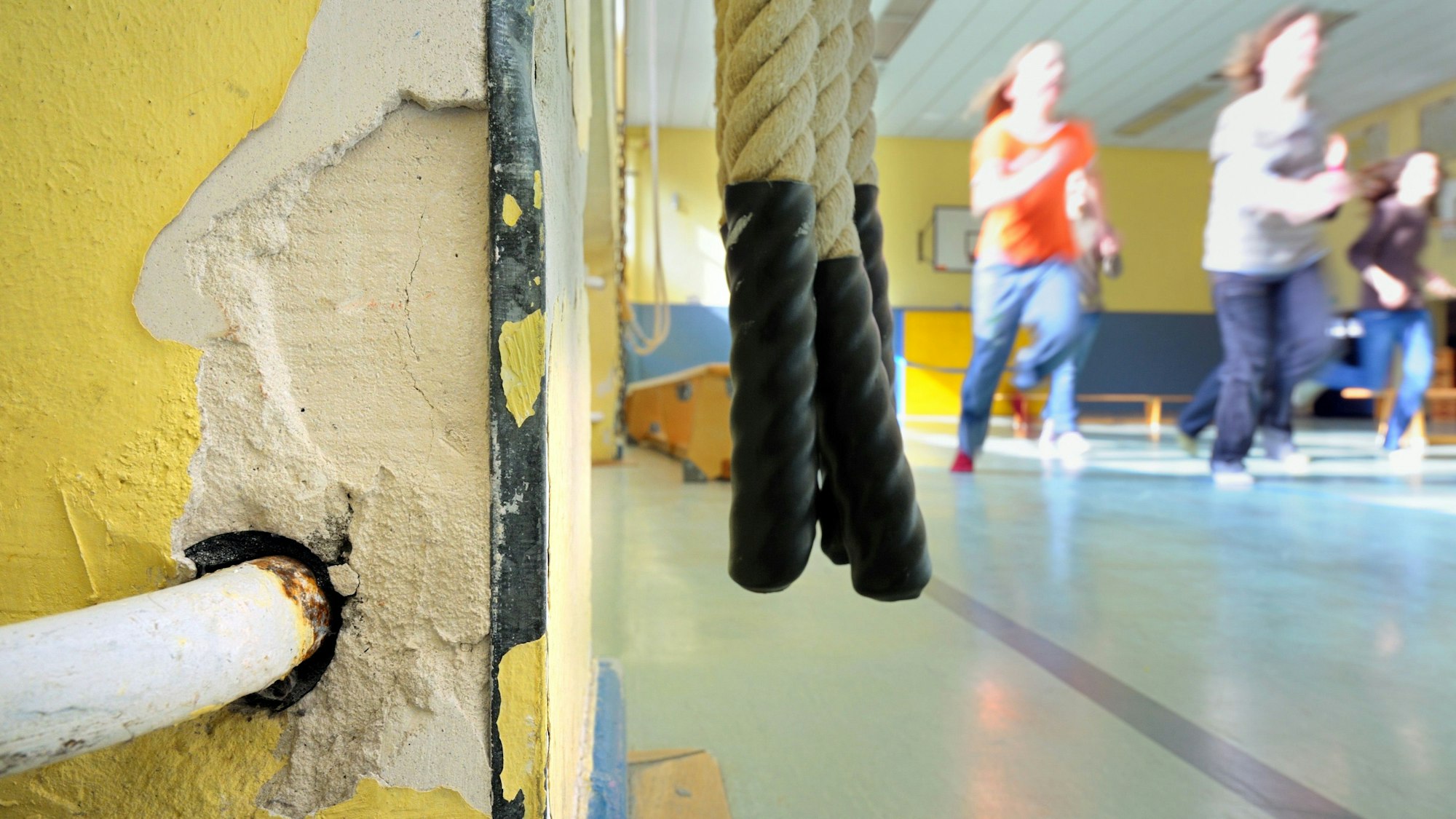 Kinder treiben Sport in einer baufälligen Turnhalle.