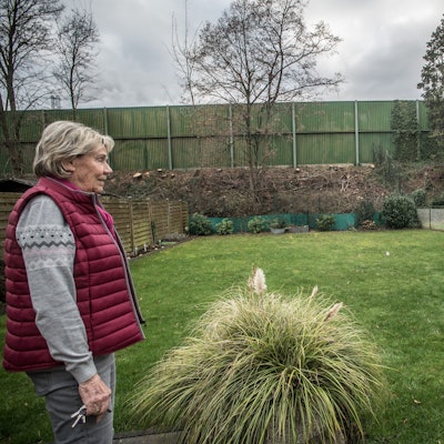 Therese Rolli im Garten, sie blickt auf die Lärmschutzwand entlang der Autobahn 3. Foto: Ralf Krieger
