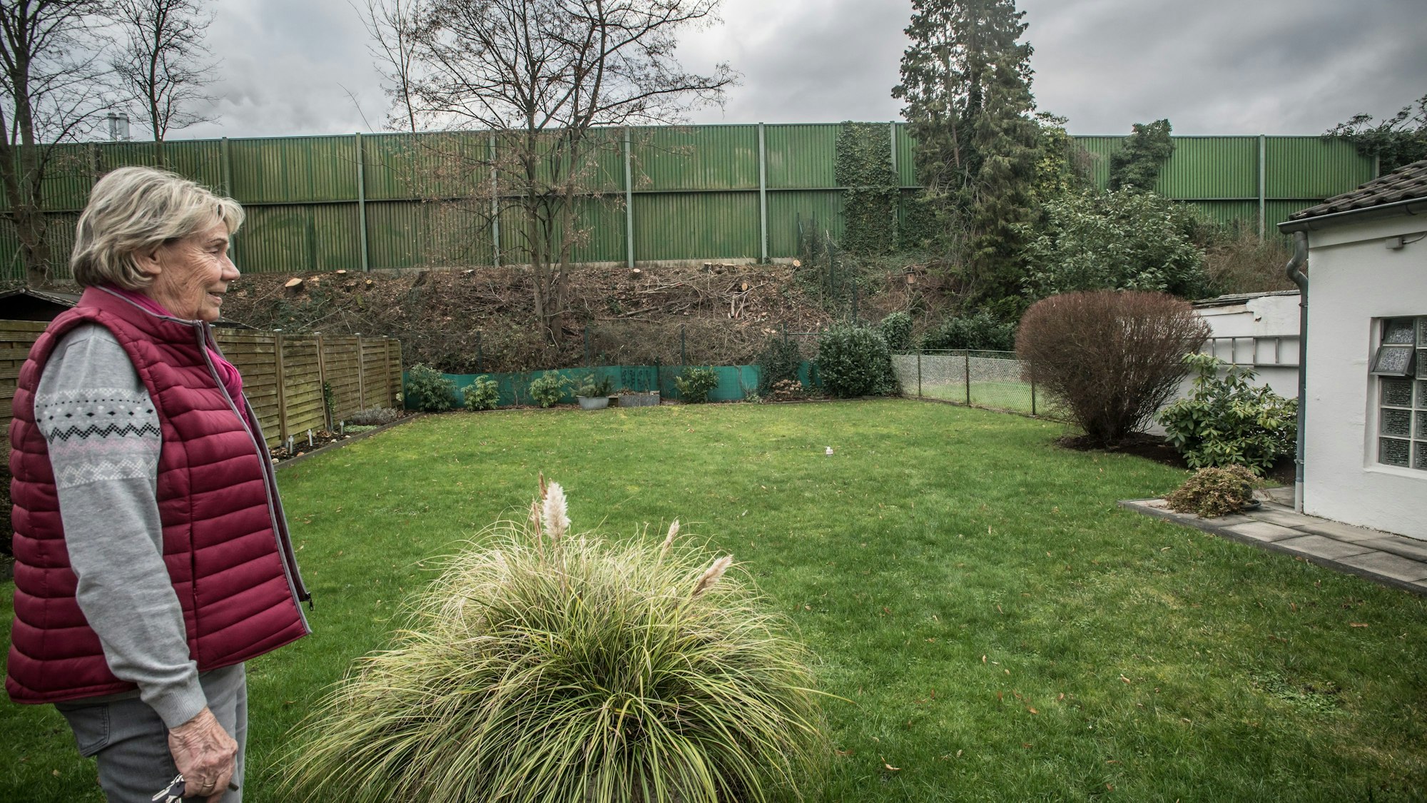 Therese Rolli im Garten, sie blickt auf die Lärmschutzwand entlang der Autobahn 3. Foto: Ralf Krieger