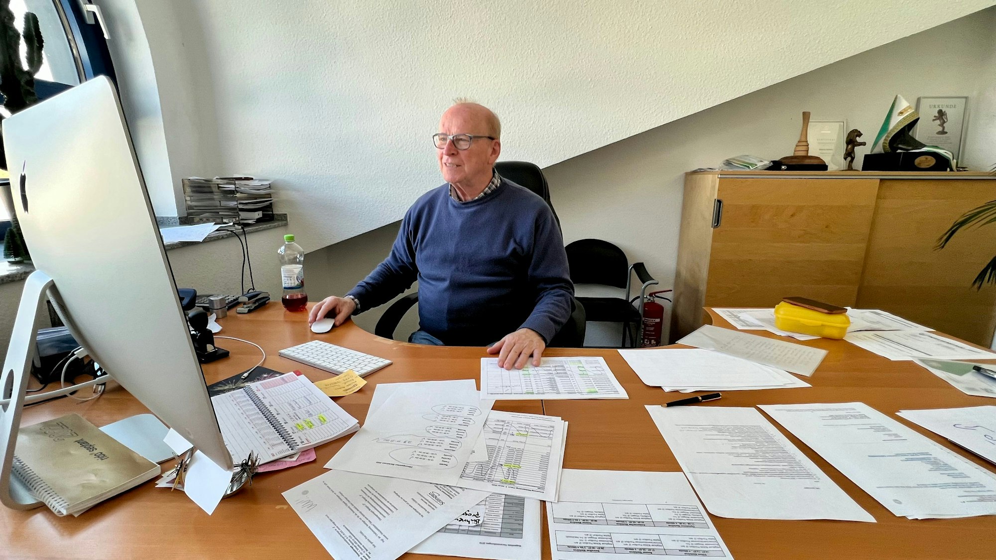 Werner Nolden an seinem mit vielen Papieren gefüllten Schreibtisch im Büro an der Schusterinsel