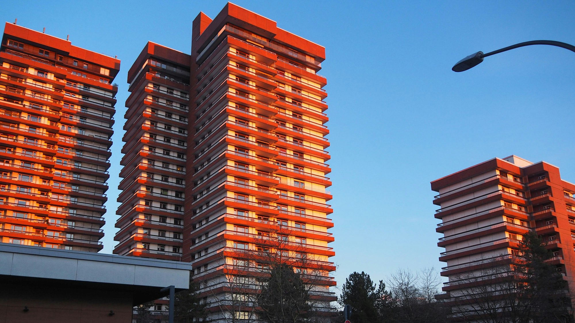 Hochhäuser im Wohnpark Bayenthal mit blauem Himmel und Sonne.