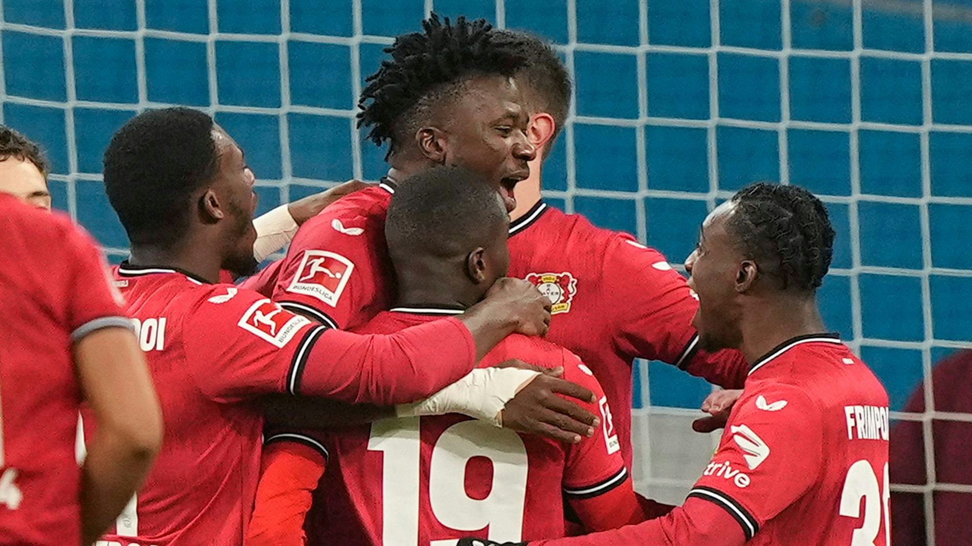 Leverkusen's Edmond Tapsoba, center, is celebrated after he scored a penalty goal during the German Bundesliga soccer match between Bayer Leverkusen and VfL Bochum in Leverkusen, Germany, Germany, Wednesday, Jan. 25, 2023. (AP Photo/Martin Meissner)