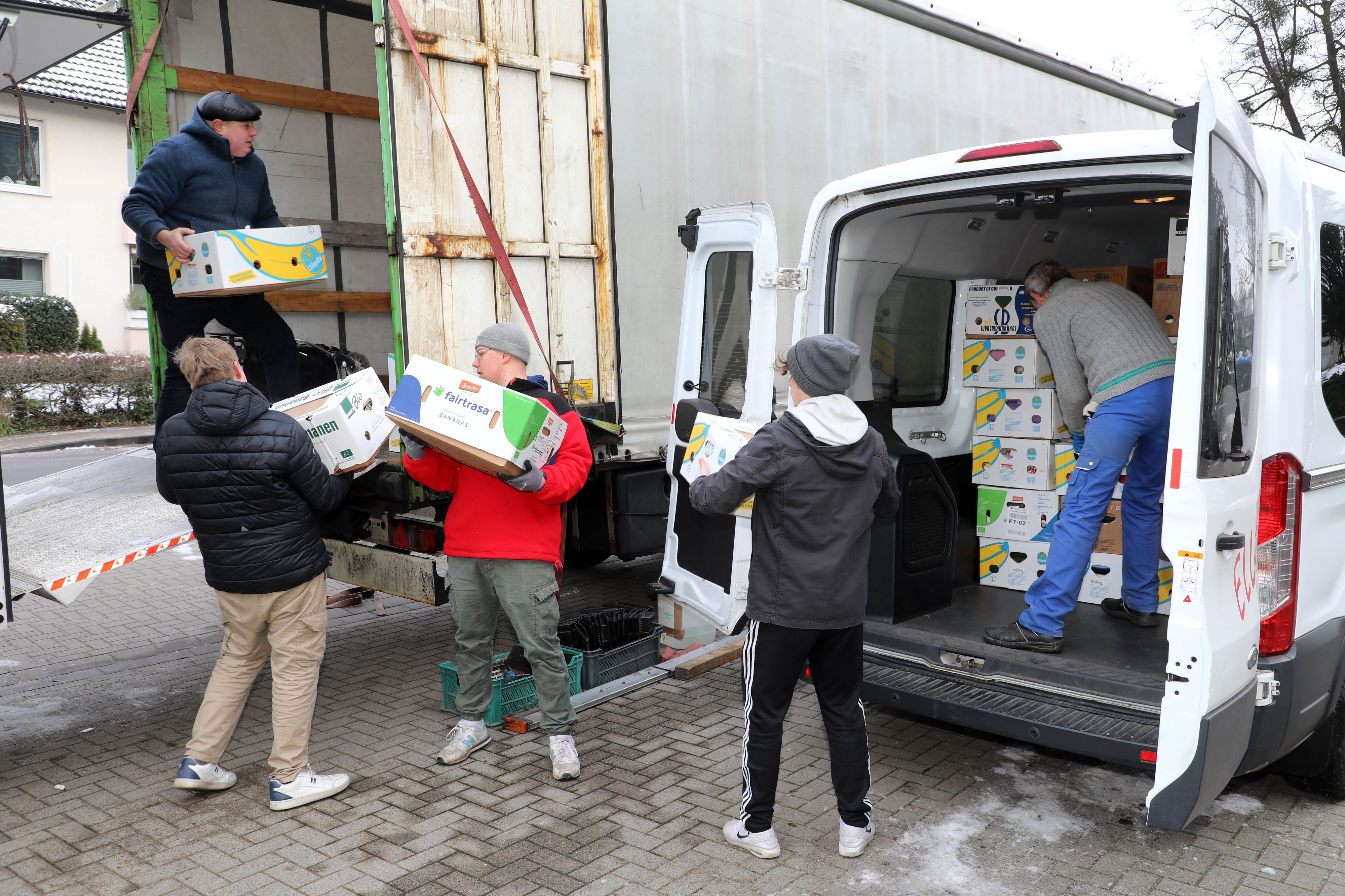 Helfer beladen einen Lastzug mit Hilfsgütern, die in Kartons verpackt sind.