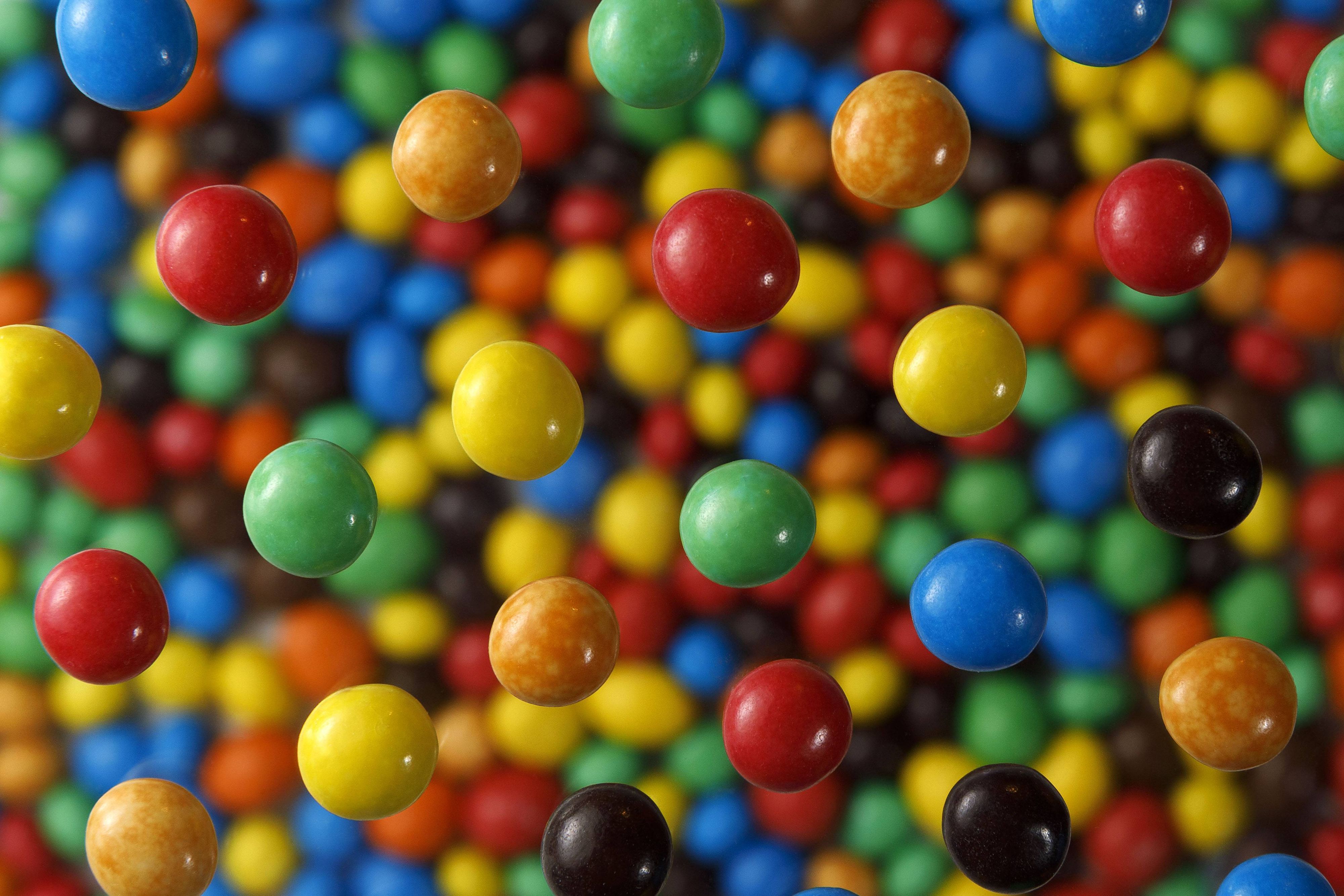 Schokolinsen der Marke „M&M’s“ von Mars Inc. auf einer Glasplatte.