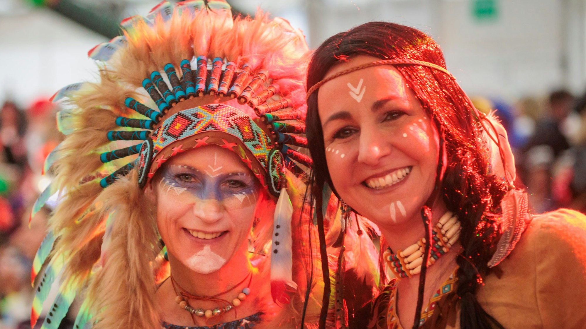 Zwei Frauen sind als Indianer kostümiert und geschminkt.