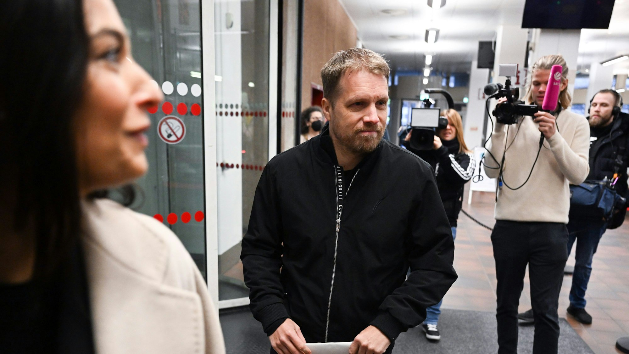 Amira und Oliver Pocher beim Betreten des Kölner Amtsgerichts, hinter ihnen steht ein Fernsehteam.