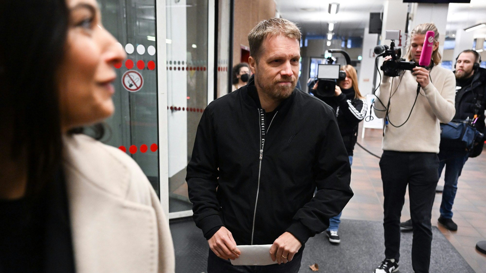 Amira und Oliver Pocher beim Betreten des Kölner Amtsgerichts, hinter ihnen steht ein Fernsehteam.