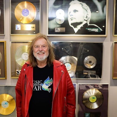 Dieter Dierks steht in seinem Büro vor einer Wand mit goldenen Schallplatten.