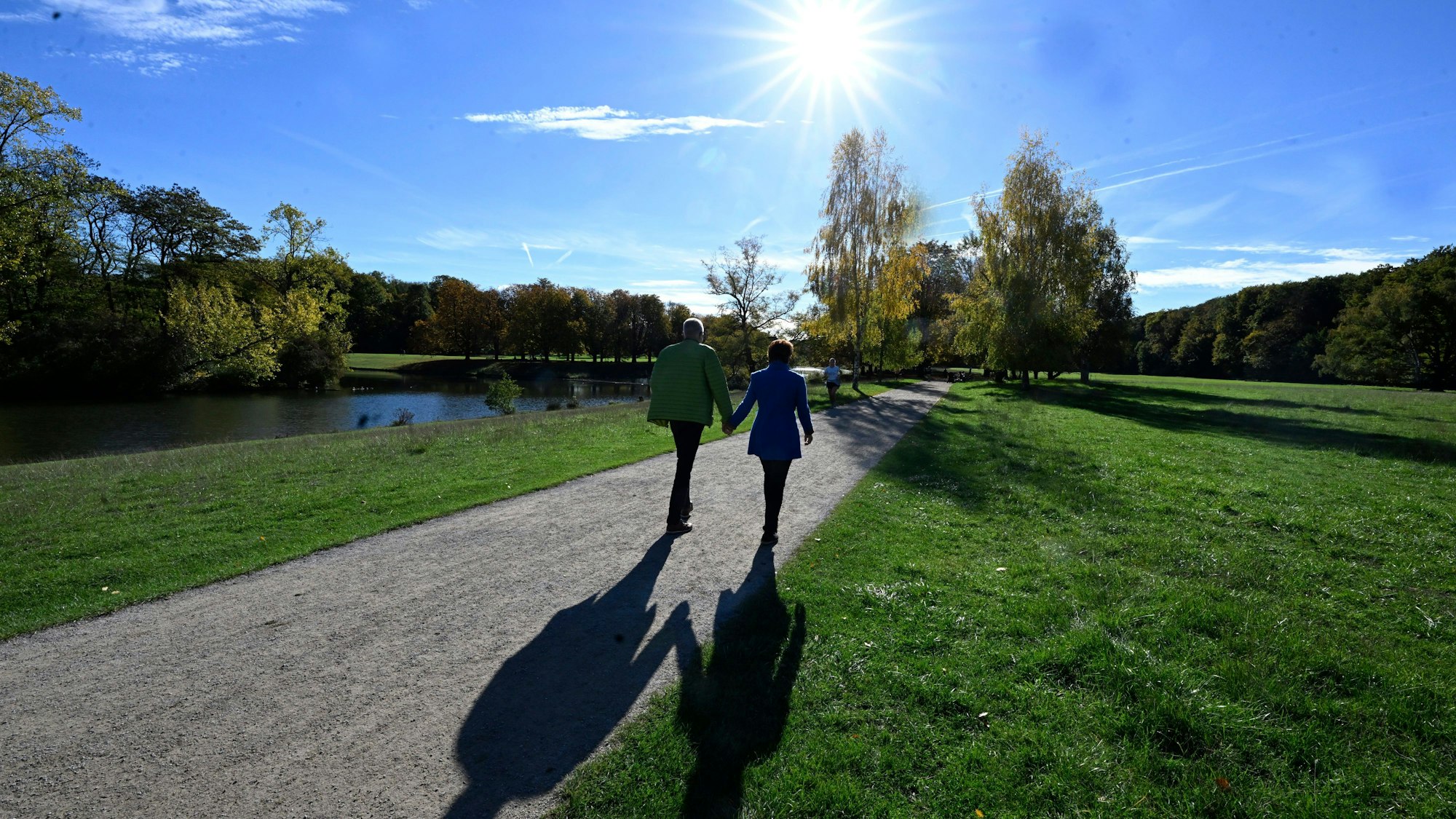 Nordrhein-Westfalen, Köln: Spaziergänger nutzen den Sonnenschein und die warmen Temperaturen für einen Spaziergang durch den Kölner Grüngürtel am Decksteiner Weiher.