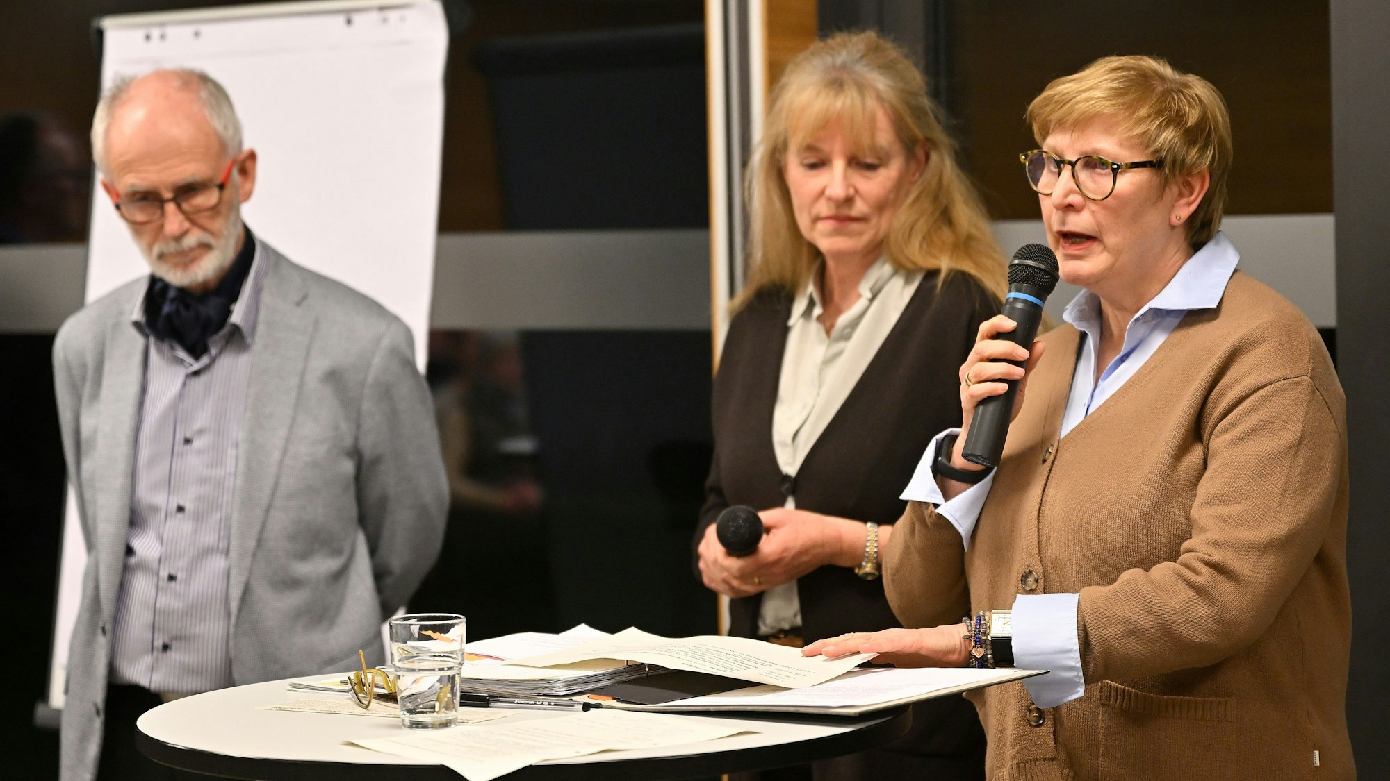 Drei Mitglieder des Kirchenvorstandes und des Orgateams Runder Tisch stehen bei der Pfarrversammlung vorne und richten Worte an die Anwesenden.