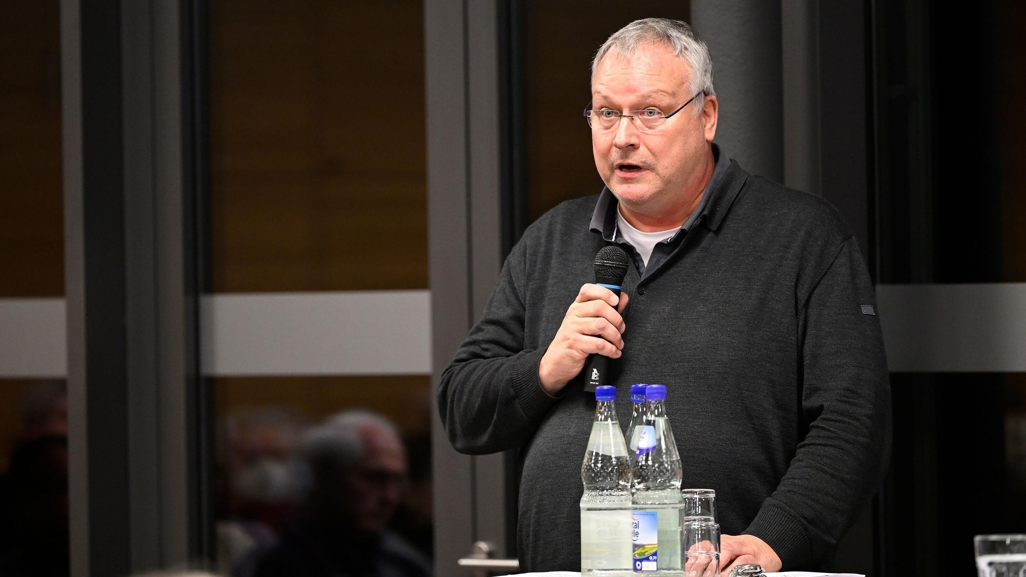 Pfarrer Winfried Kissel spricht in ein Mikrofon.