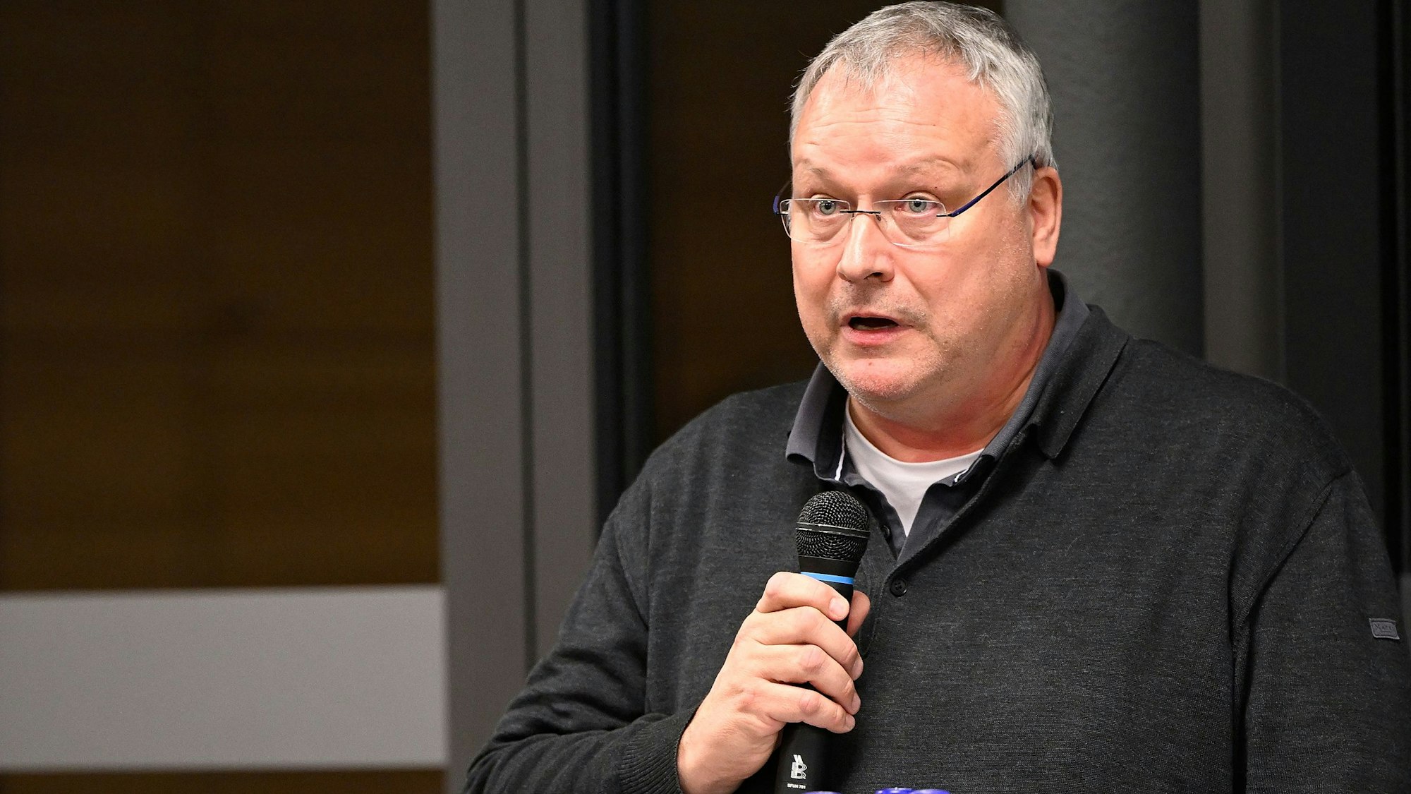 Pfarrer Winfried Kissel spricht in ein Mikrofon.