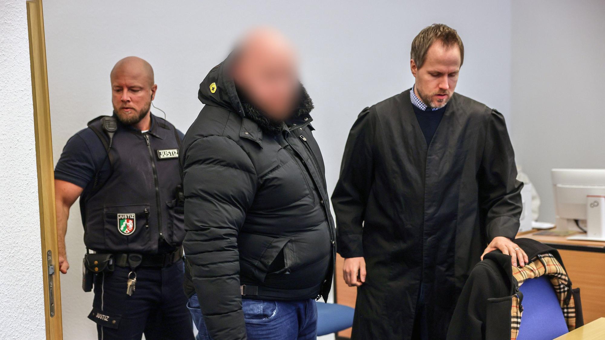 Der Angeklagte (M.) steht im Gerichtssaal neben seinem Verteidiger Ingmar Rosentreter (r.).