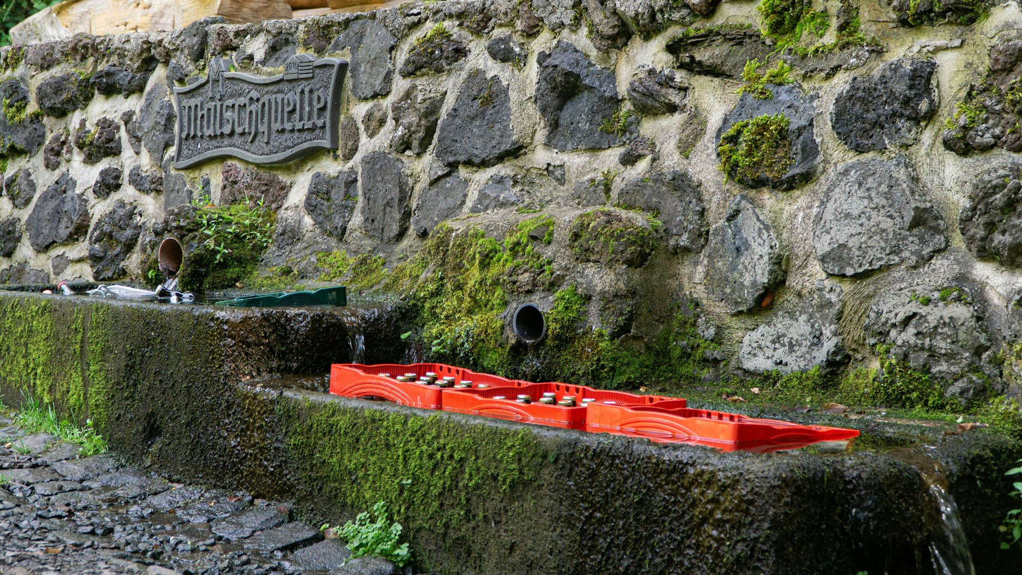 Bierkästen in einem mit Wasser gefüllten Steinbecken