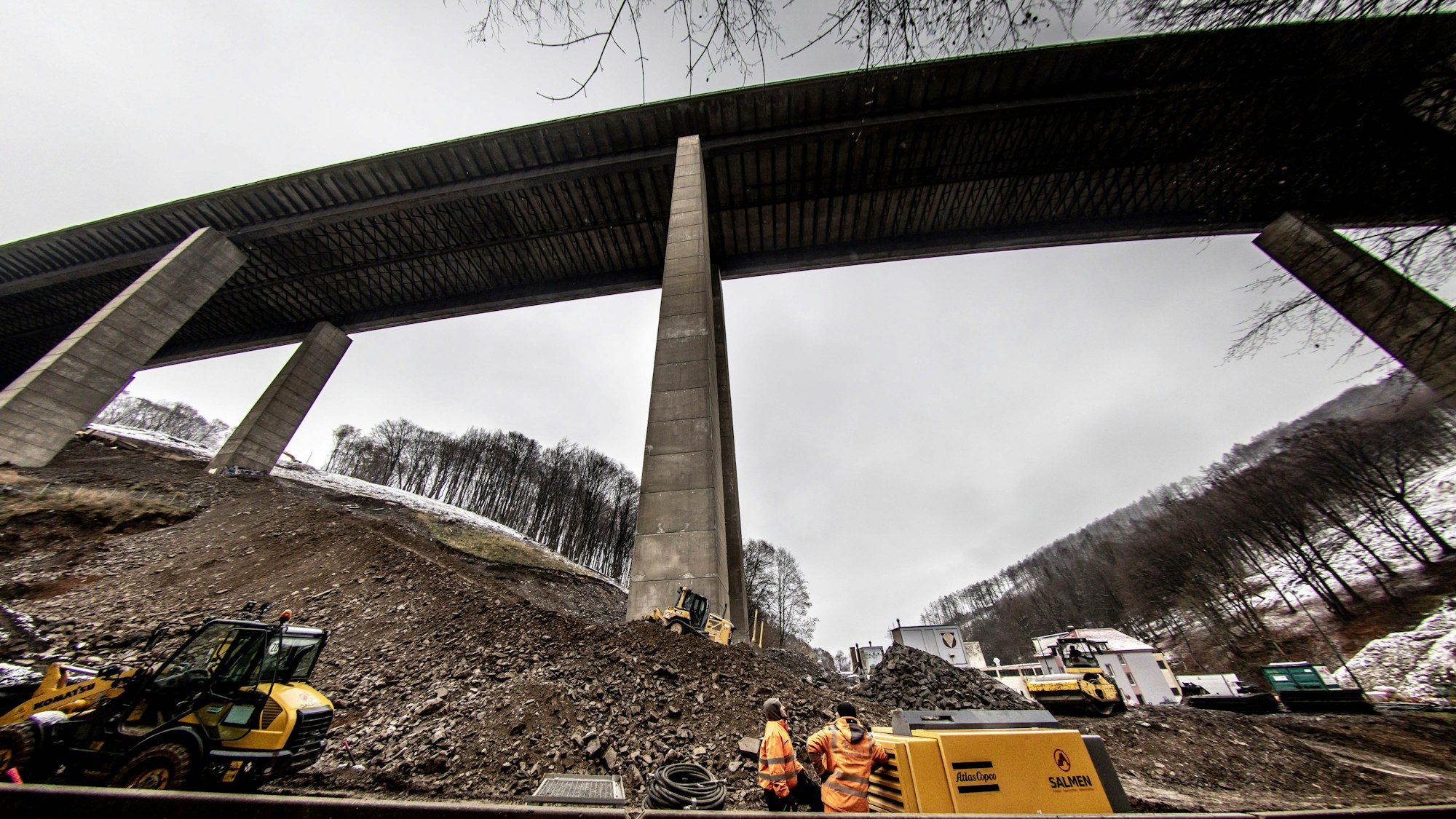 Die Rahmede-Talbrücke ist von unten aufgenommen zu sehen vor bedecktem Winterhimmel. Die hohen Stelzen ragen nach oben, die Fahrbahnunterseite zieht sich wie ein dunkelgraues Band durch das Foto.