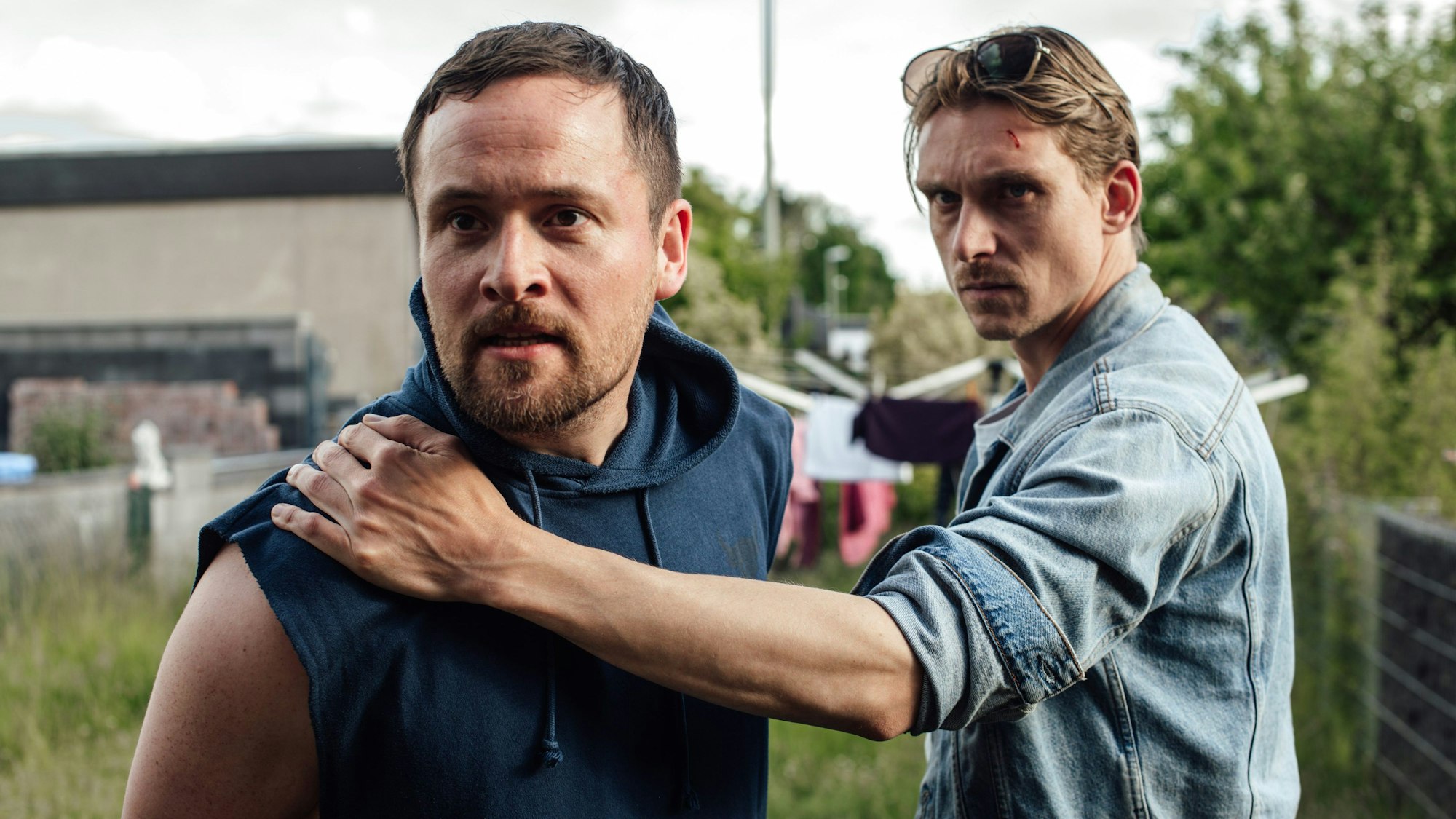 Zwei Männer stehen im Garten