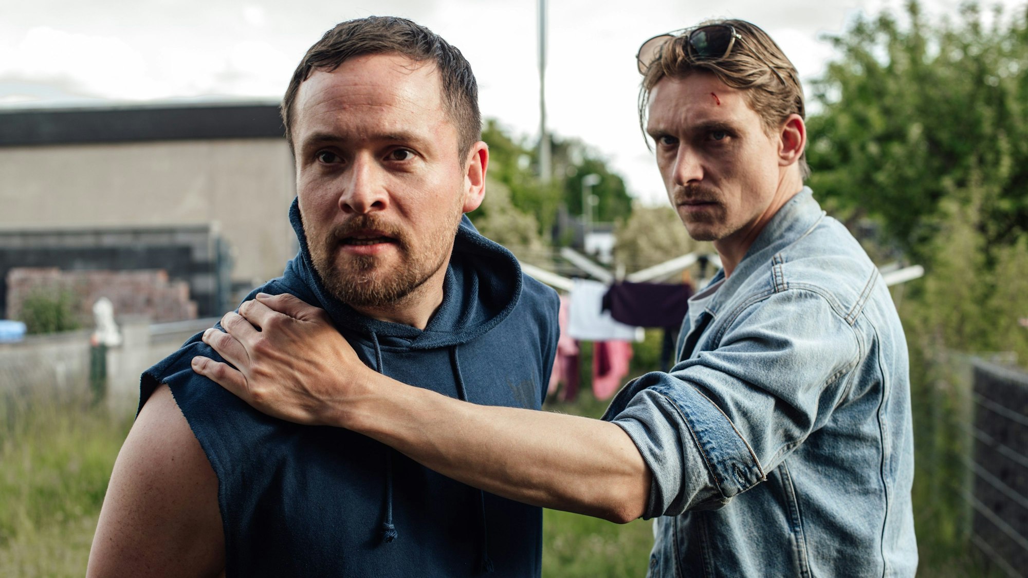 Zwei Männer stehen in einem Garten.