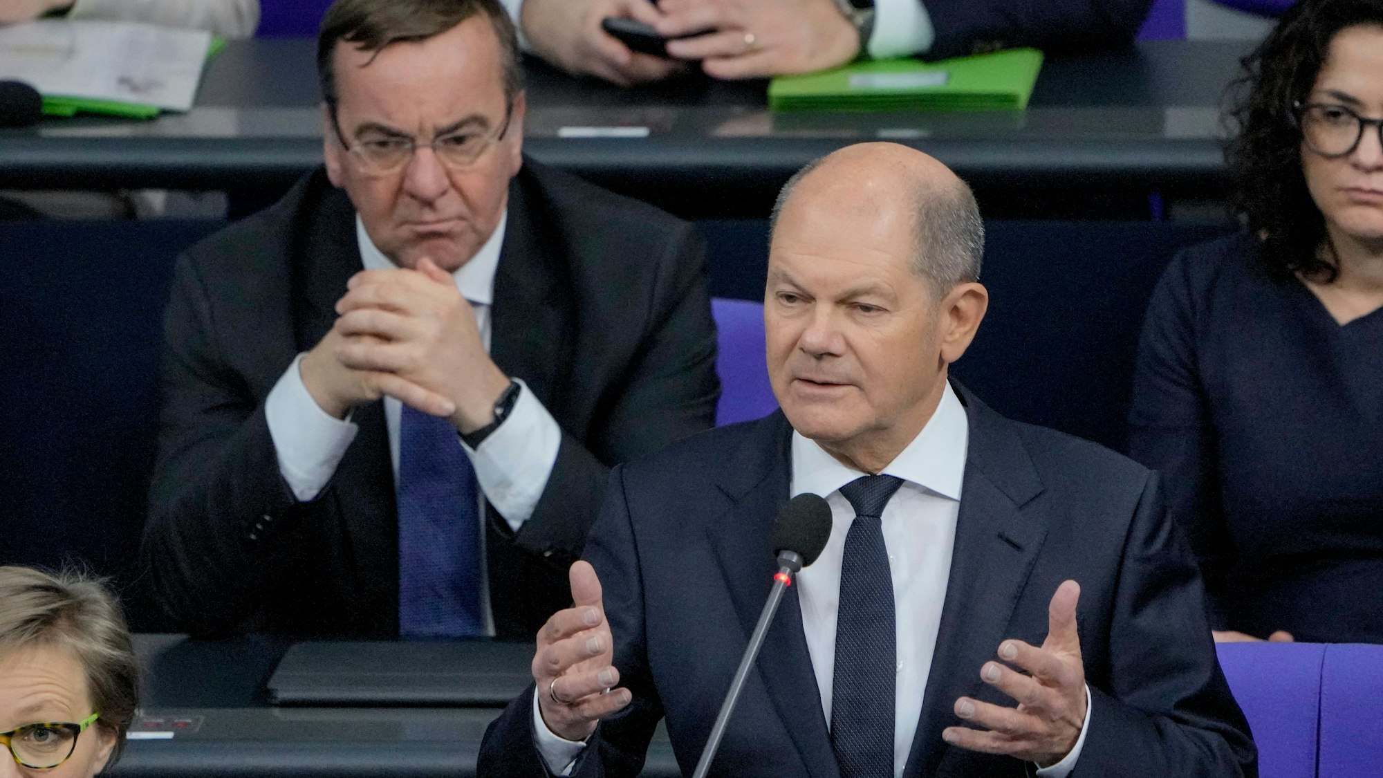 Bundeskanzler Olaf Scholz begründet im Bundestag gestikulierend seine Entscheidung, Leopard-Panzer an die Ukraine zu liefern. Im Hintergrund links Verteidigungsminister Boris Pistorius.