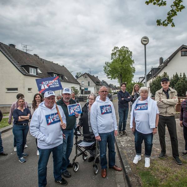 Rund 20 Menschen stehen auf der Straße und protestieren gegen den Autobahnausbau.