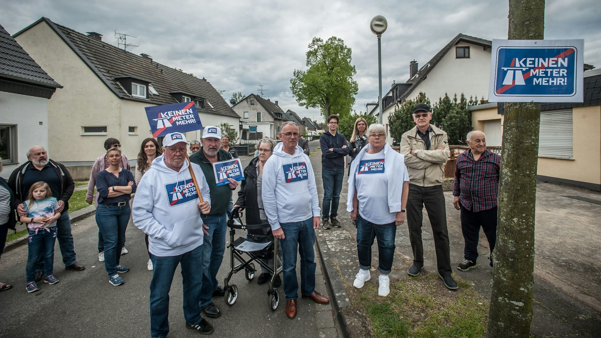 Rund 20 Menschen stehen auf der Straße und protestieren gegen den Autobahnausbau.