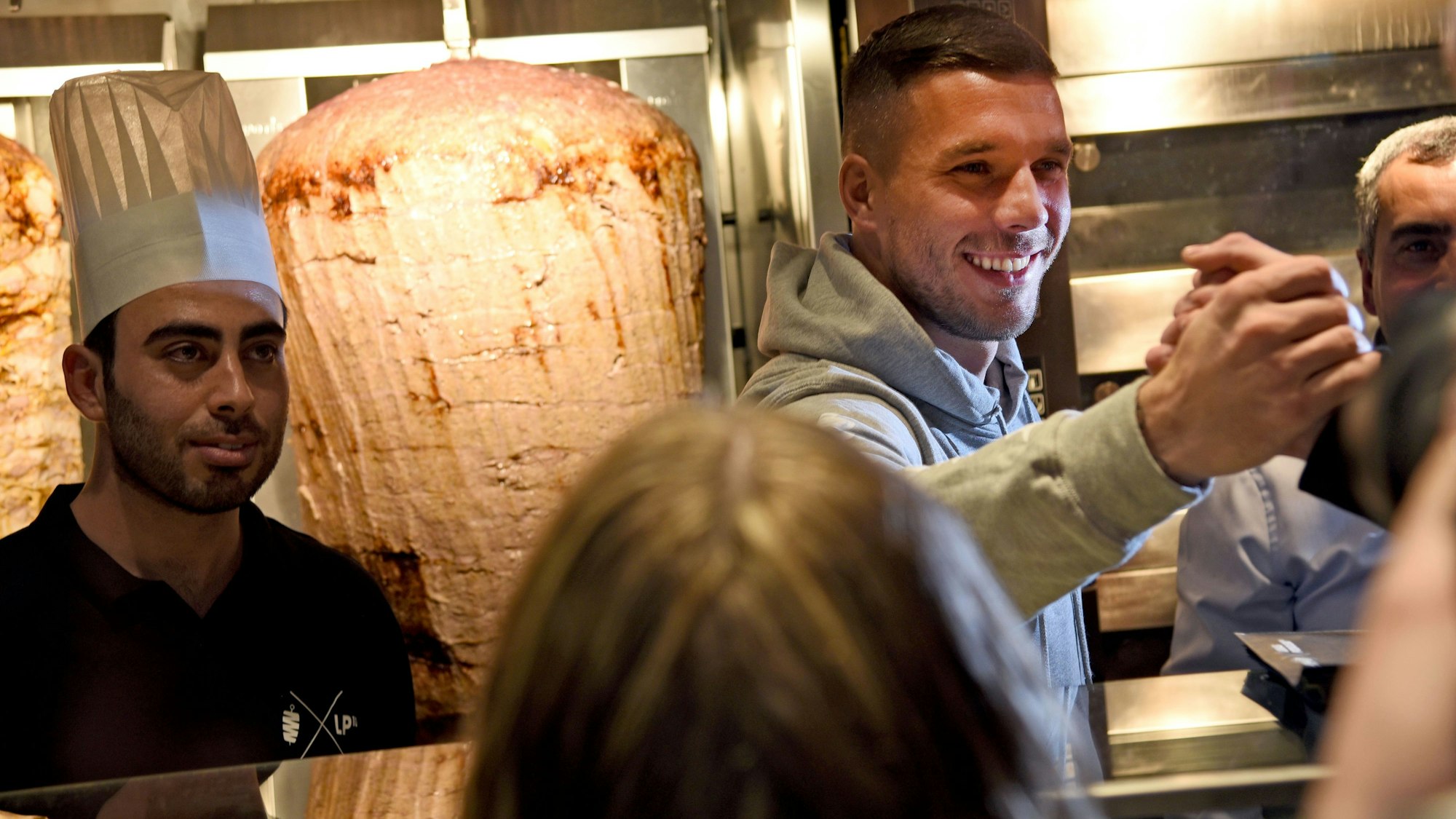 Lukas Podolski begrüßt Menschen bei der Eröffnung eines Mangal-Döner-Ladens 2018.