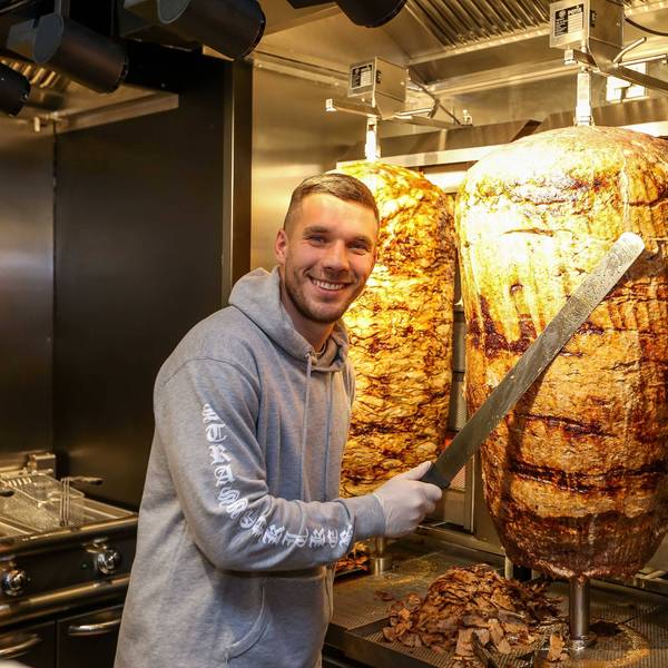 Fußball-Weltmeister Lukas Podolski posiert bei der Eröffnung eines Mangal-Döner-Ladens 2018 an einem Dönerspieß.