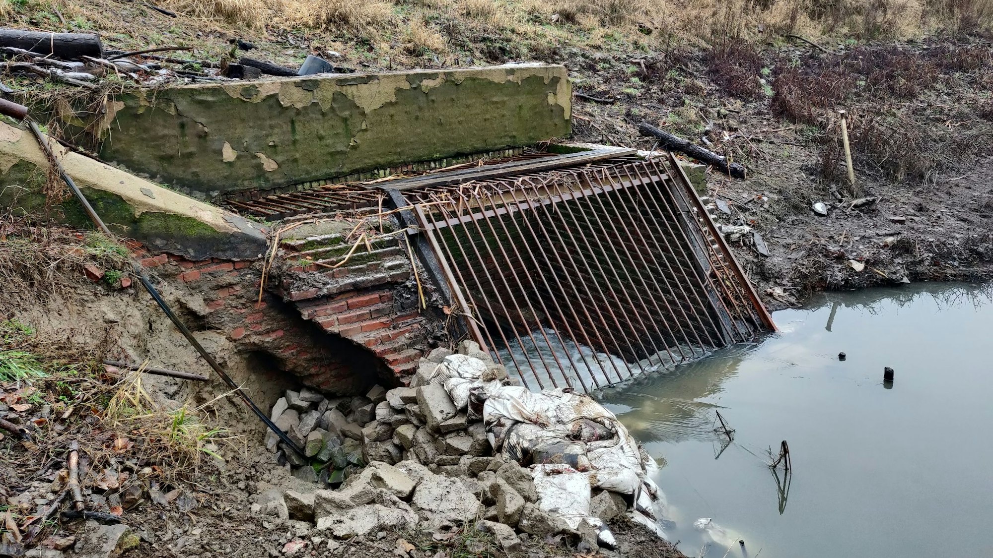 Die unterspülte Böschung neben dem Rechenbauwerk ist mit Steinen und Sandsäcken provisorisch befestigt worden.