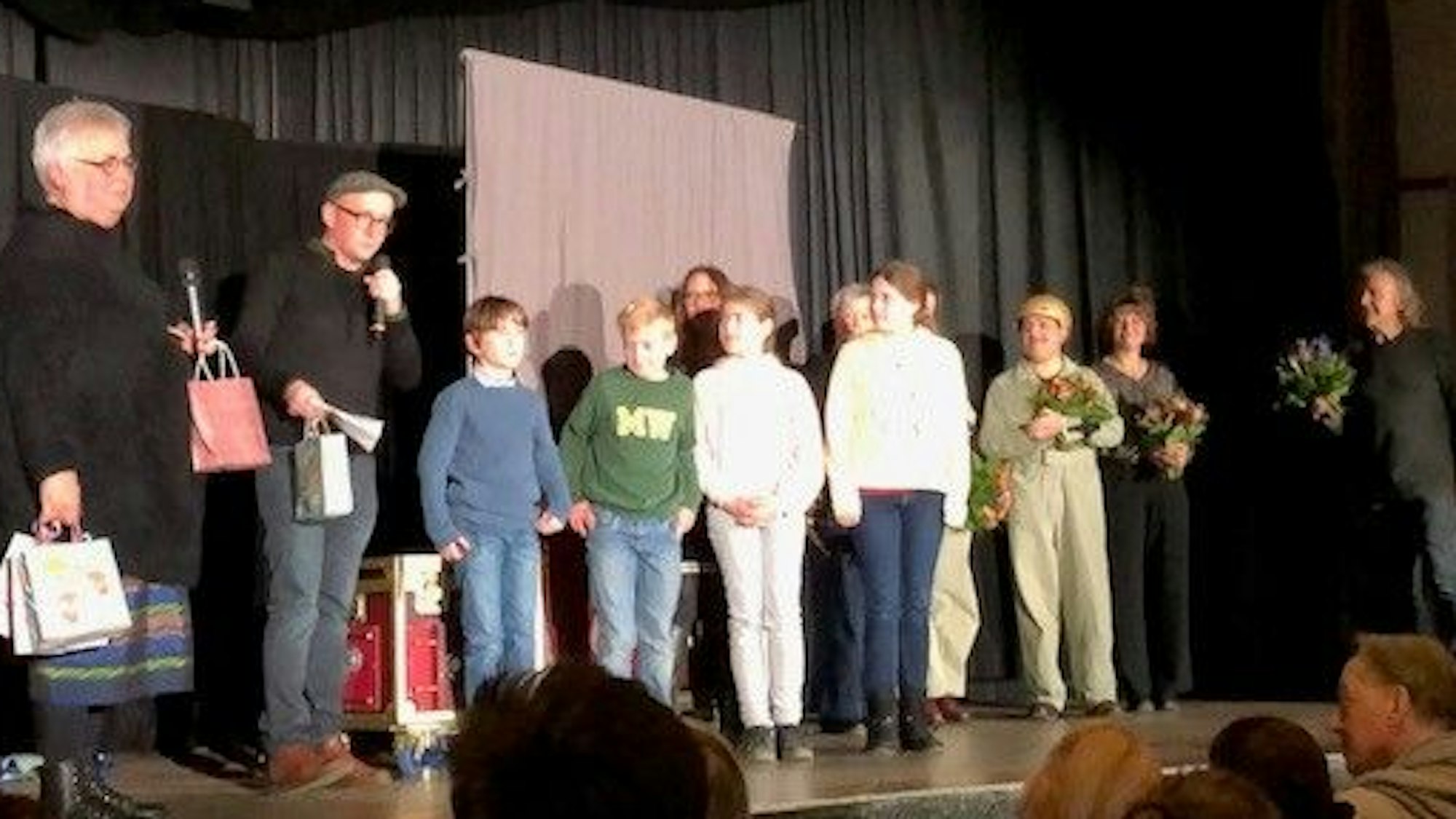 Das Team von Zartbitter Köln steht auf der Bühne mit Kindern der Domsingschule Köln, die die Songs für das Theaterstück eingesungen haben.