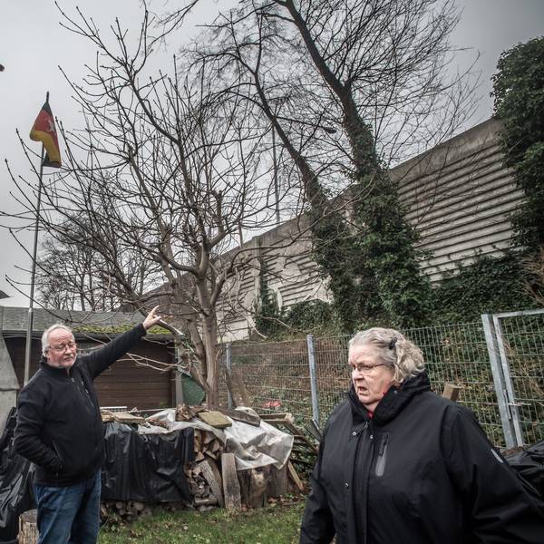 Gisela Kronenberg im Garten von Rolf Luxem (Ratherkämp 8): zwei meter höher als die alte Lärmschutzmauer wird die neue Mauer, höher als die Fahnenstange sie stünde mitten im garten (etwa beim Trampolin). Foto: Ralf Krieger