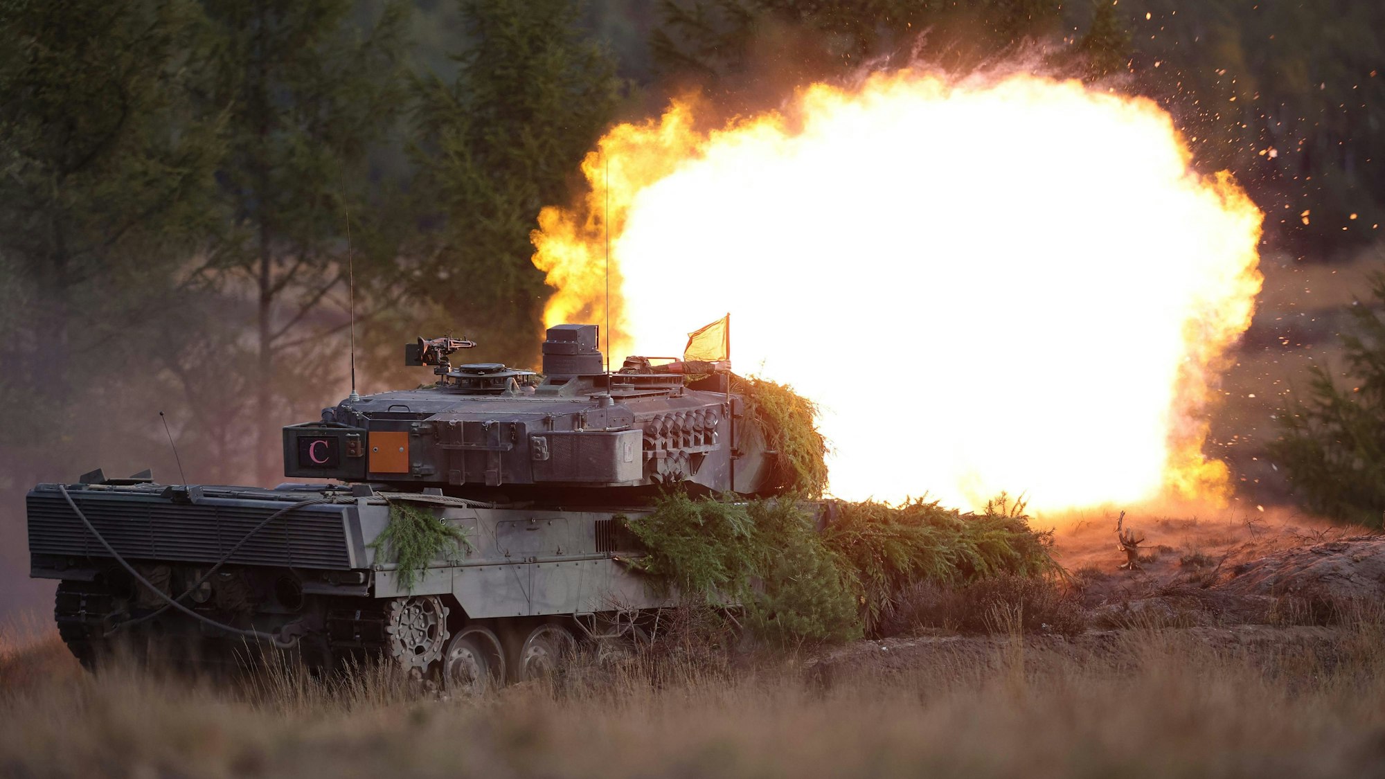 Ein Leopard 2 Panzer feuert einen explodierenden Schuss ab