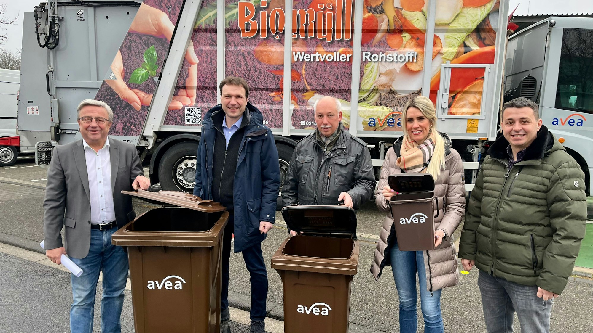 Hans-Jürgen Sprokamp, Alexander Lünenbach, Michael Czyborra, Anika Hagt und Sven Tahiri stehen mit zwei Biotonnen auf einer Straße.