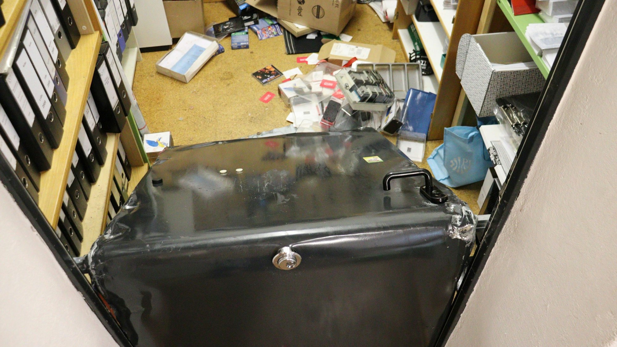 Die Stahltür zu einem kleinen Lagerraum ist über der Klinke gefaltet.