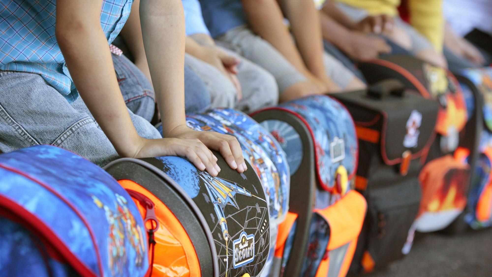 Mehrere Erstklässler warten auf ihre Einschulung in eine Grundschule.