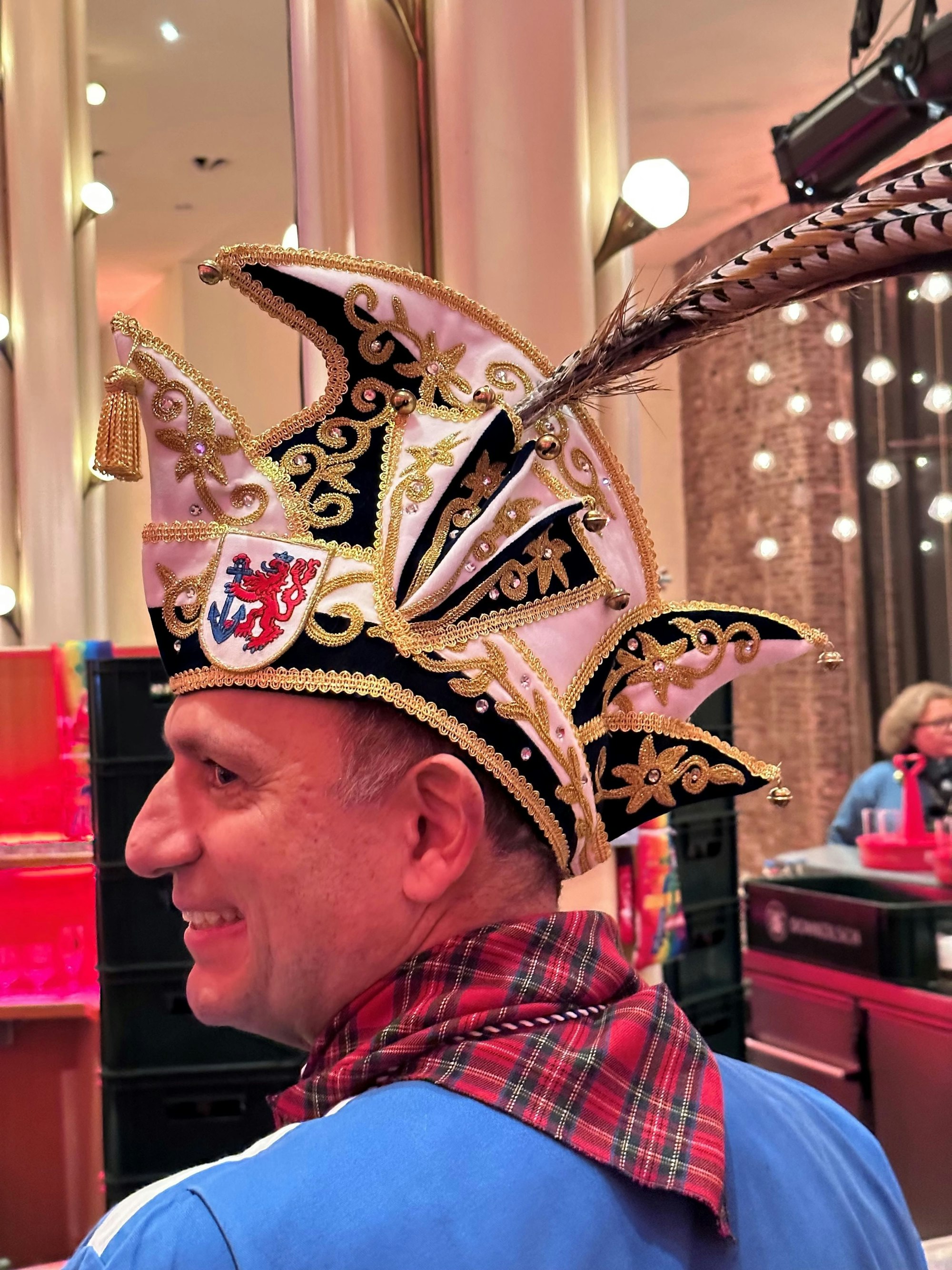 Ein Mann mit schwarz-weißer, goldbesetzter Narrenkappe.