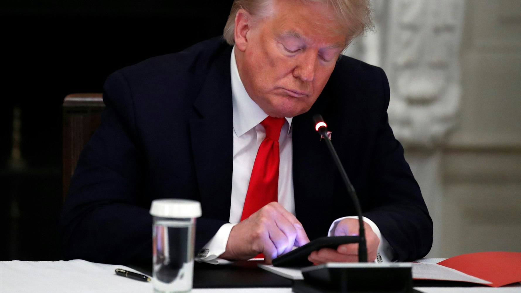 Donald Trump tippt auf seinem Smartphone.