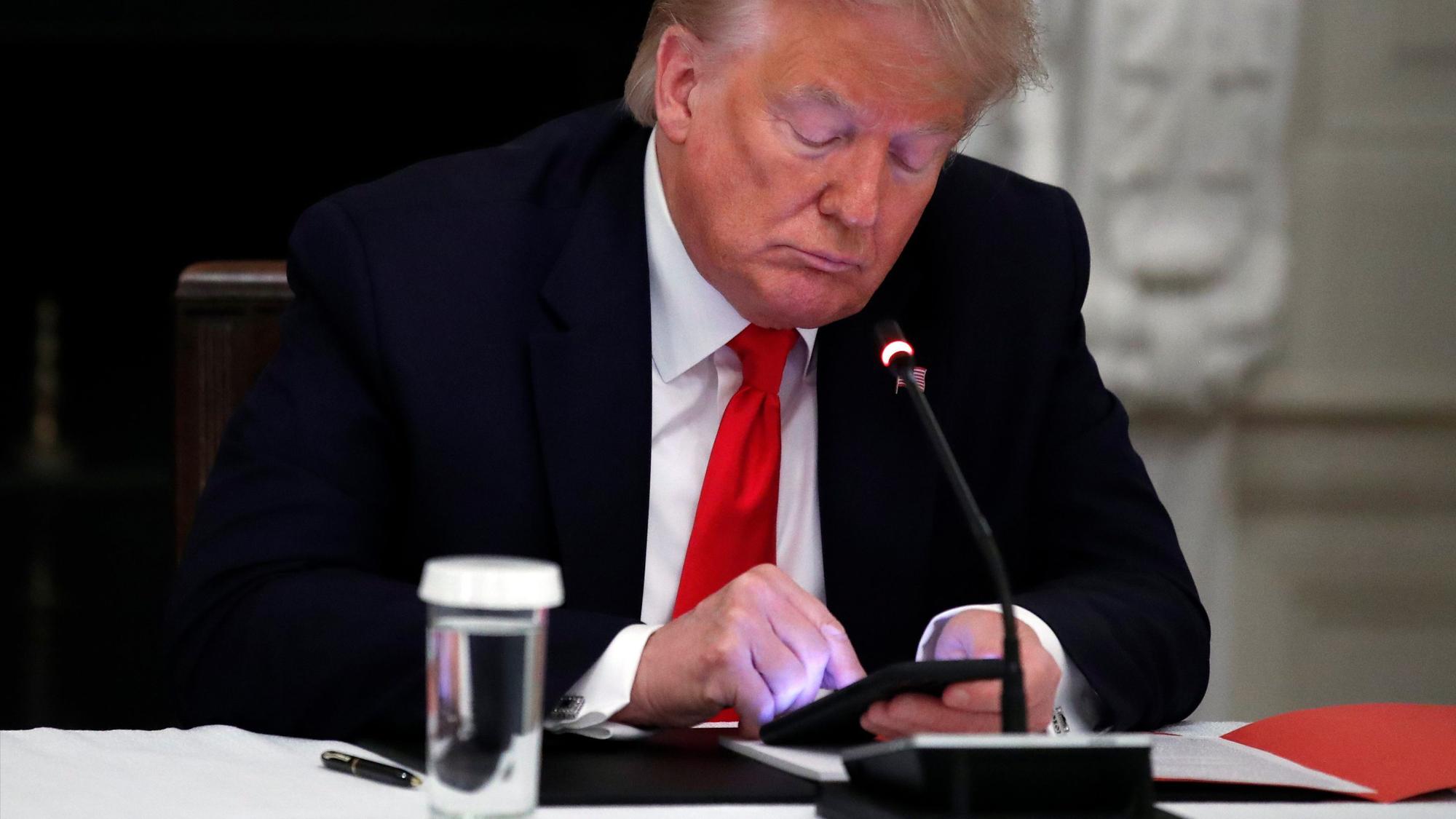Donald Trump tippt auf seinem Smartphone.