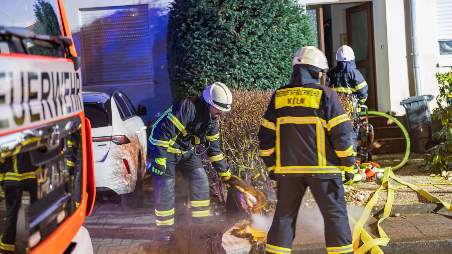 Löscharbeiten vor einem Wohnhaus in Köln-Porz