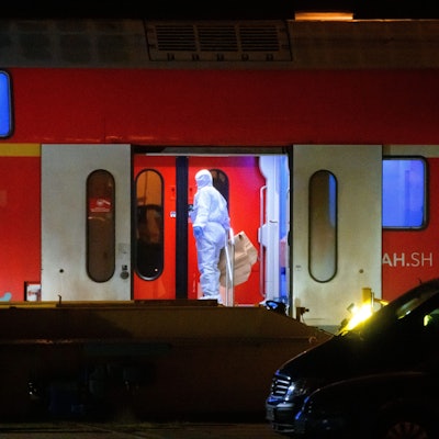 Ein Ermittler im weißen Schutzanzug arbeitet in dem Regionalzug, der auf ein Abstellgleis in Neumünster gefahren worden war.