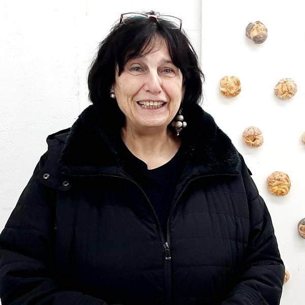 Ellen Loh-Bachmann zwischen Narrenkappe und auf einer Wandtafel befestigten Brötchen.